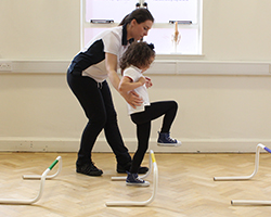 Child sitting on exercise ball during assessment.