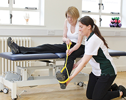 Elderly female uses dumbell for hand weight exercise.