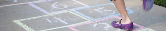 Children playing hopscotch outside.