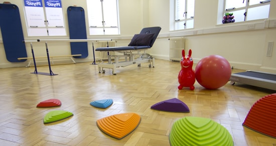 Interior shot of Manchester OT clinic with stepping blocks on the ground for therapy.