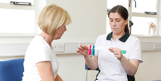 ManchesterOT therapist goes through exercise with patient.